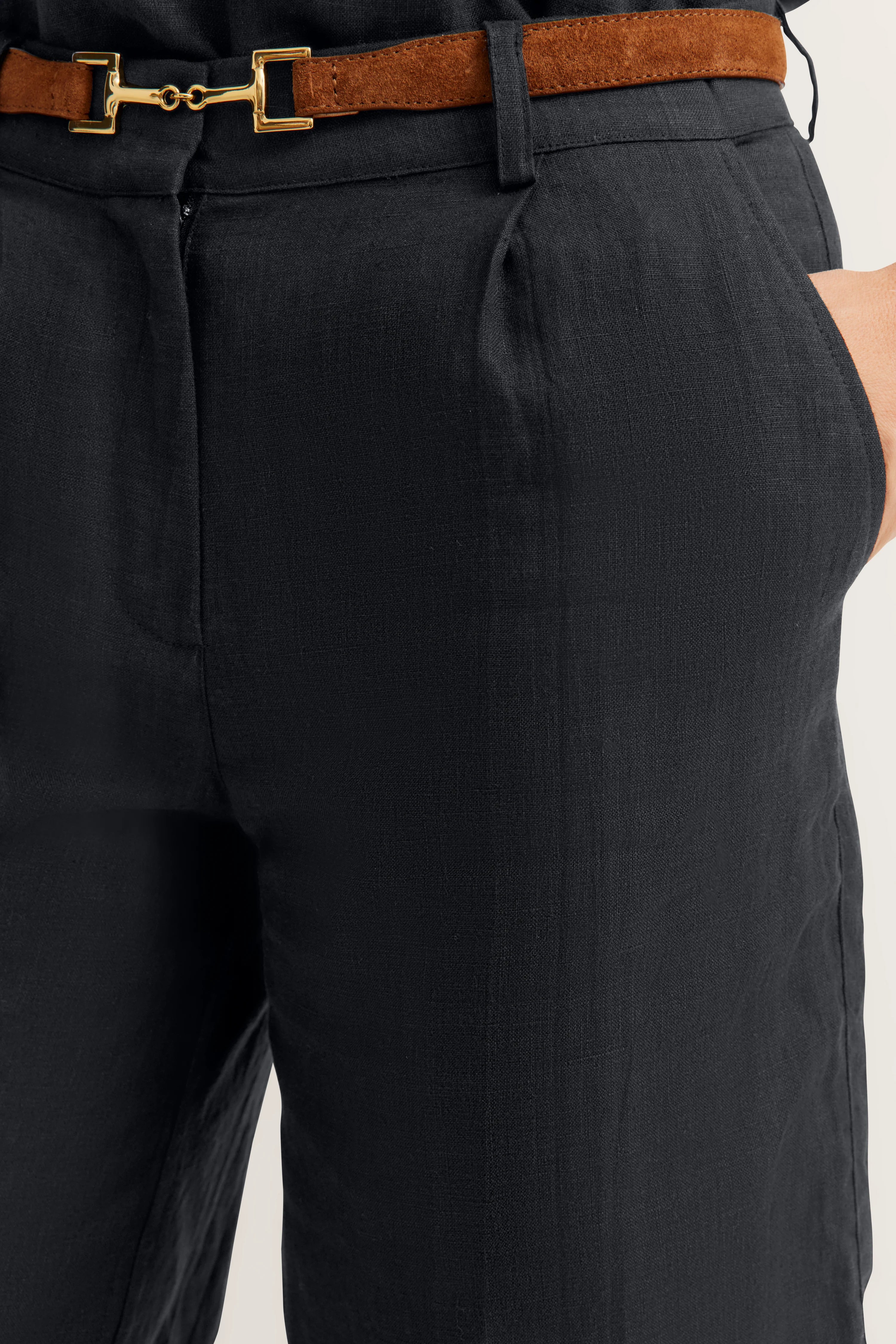 Zwarte bugatti linnen broek met bruine riem, detailopname.