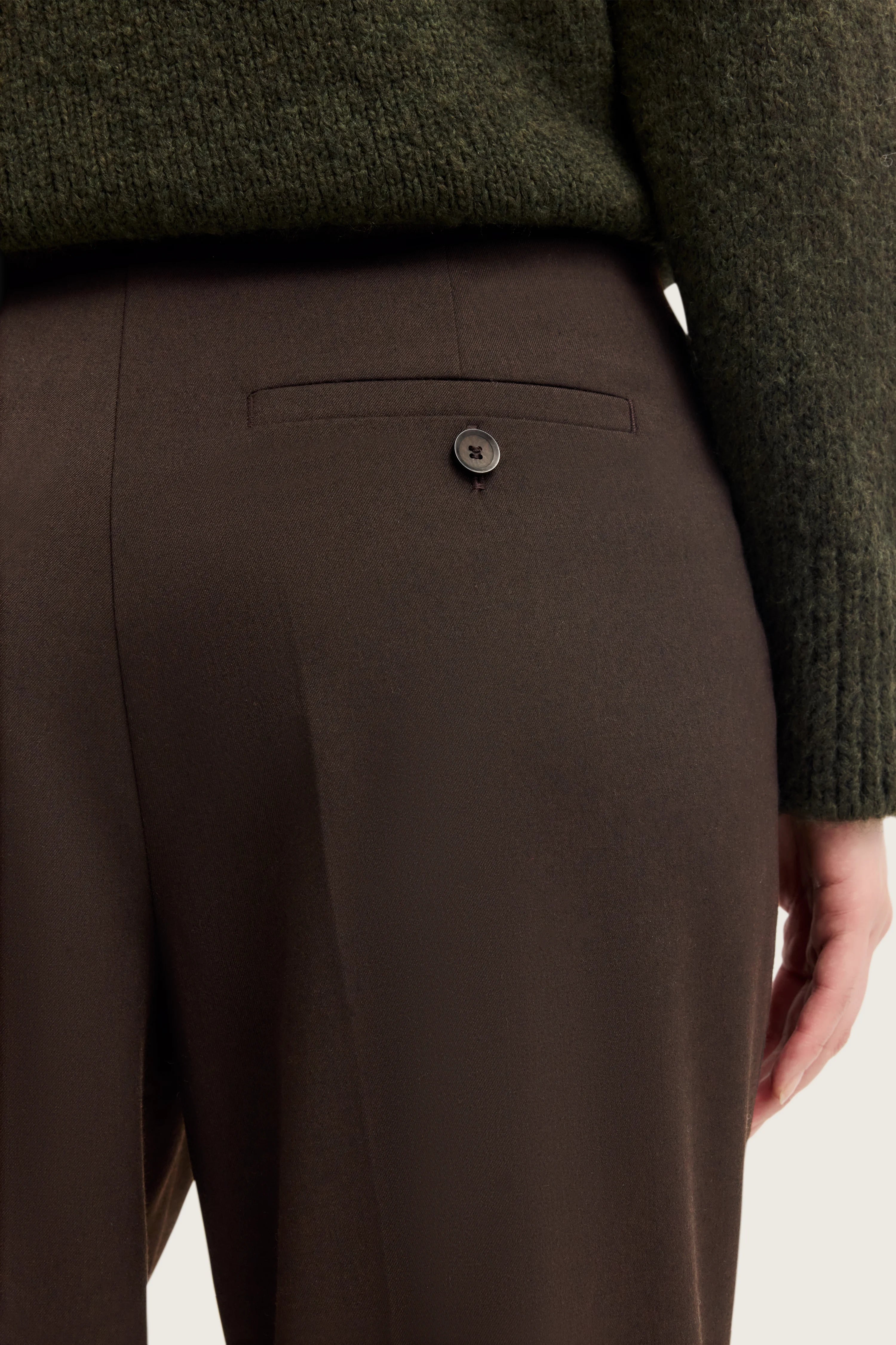 Dunkelgrüner Pullover mit brauner Hose, Detailaufnahme, stofflich elegant, bugatti Stil.