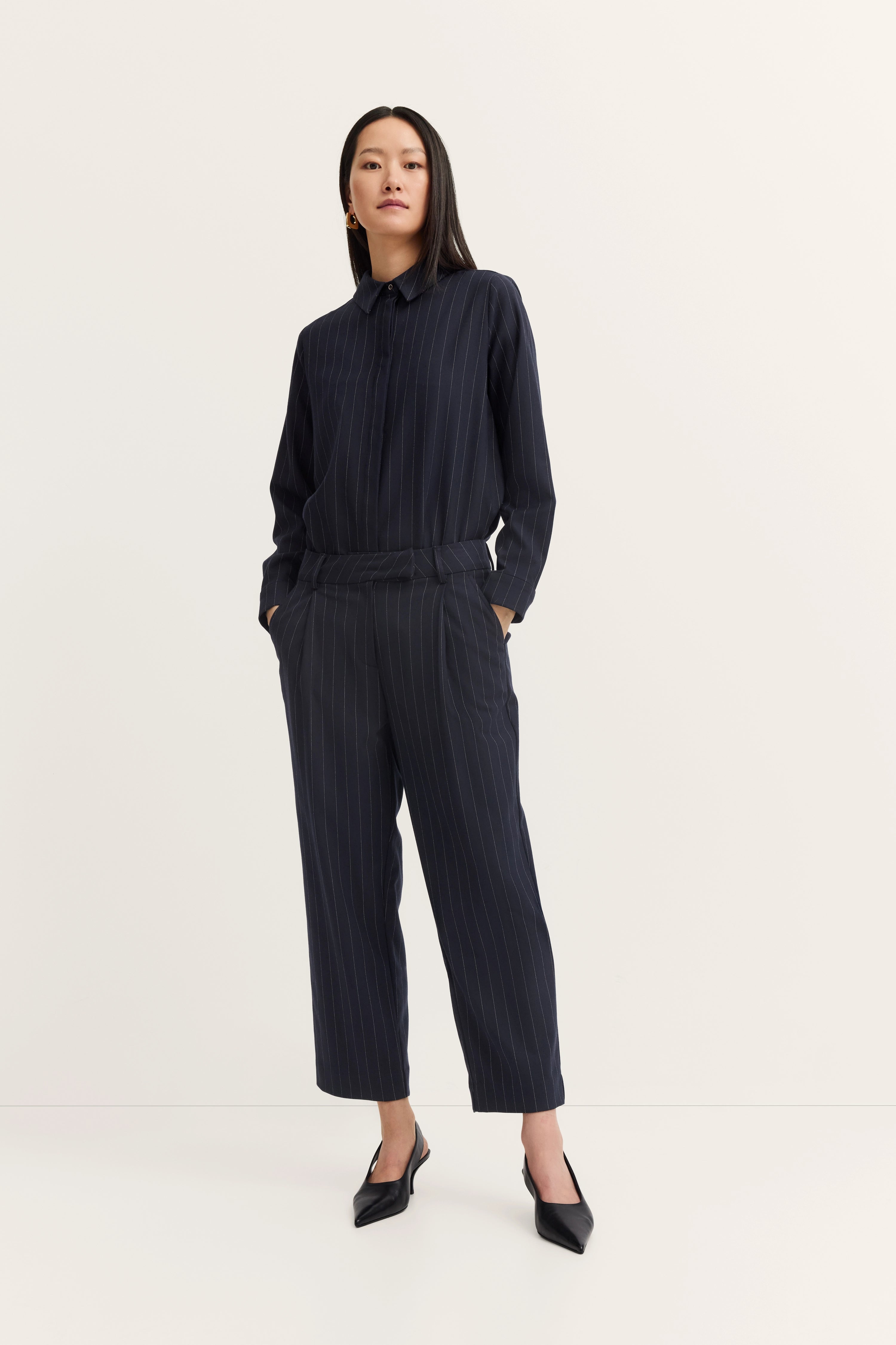 Modell trägt navy gestreiften bugatti Anzug, freier Stand, Hände in den Hosentaschen, Eleganz und Stil.
