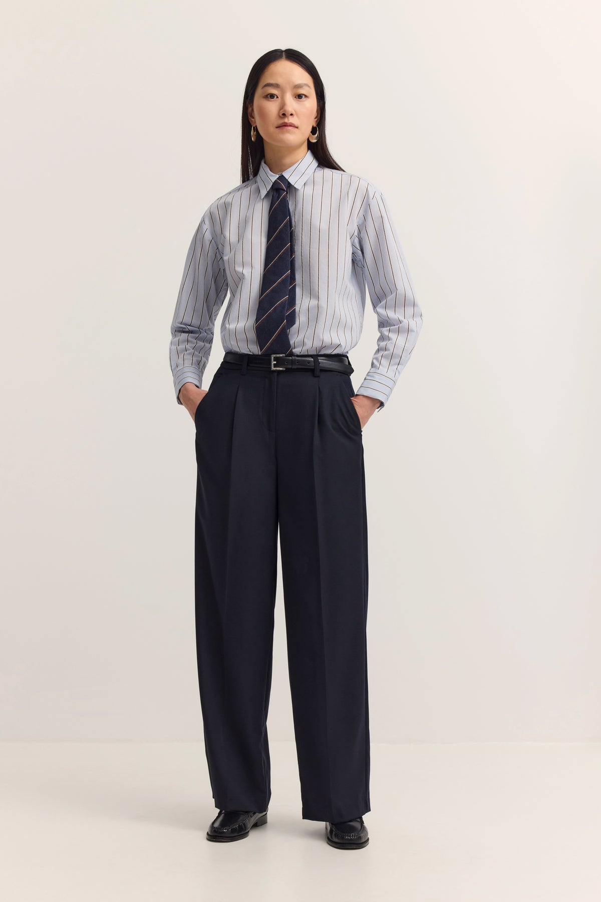 Streifenhemd in Blau mit dunkler Hose und Gürtel, Detailaufnahme, bugatti Stil.