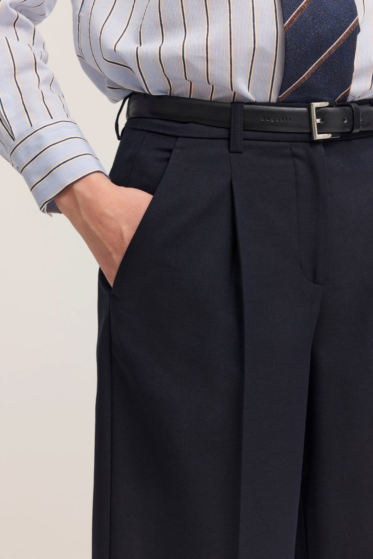 Dunkelblaue Hose in Büstenbild mit gestreiftem Hemd, Rückansicht, minimalistischer Stil.