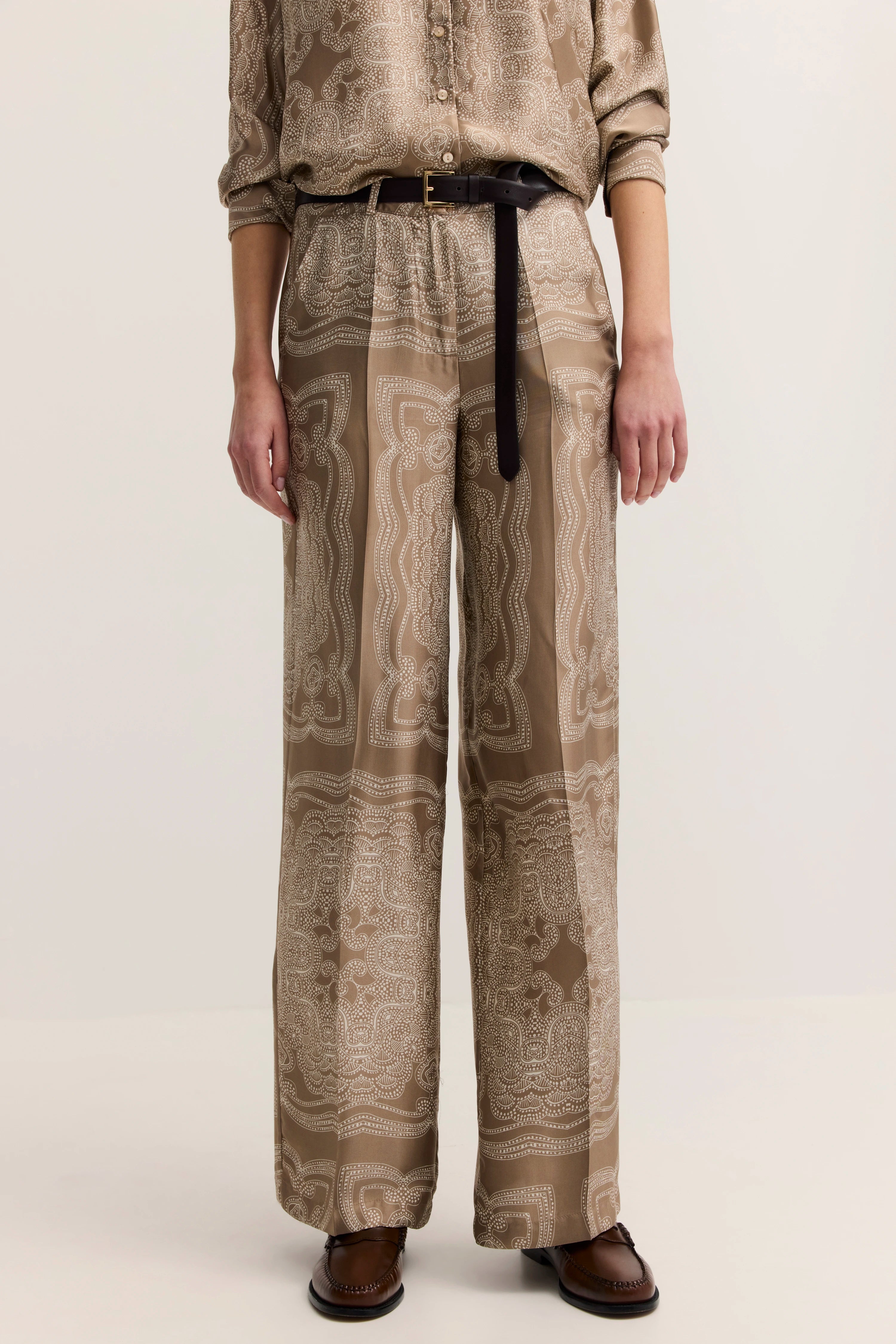 Beige gemustertes Outfit mit Hemd und Hose, legeres Büstenbild, geerdete Eleganz von bugatti.
