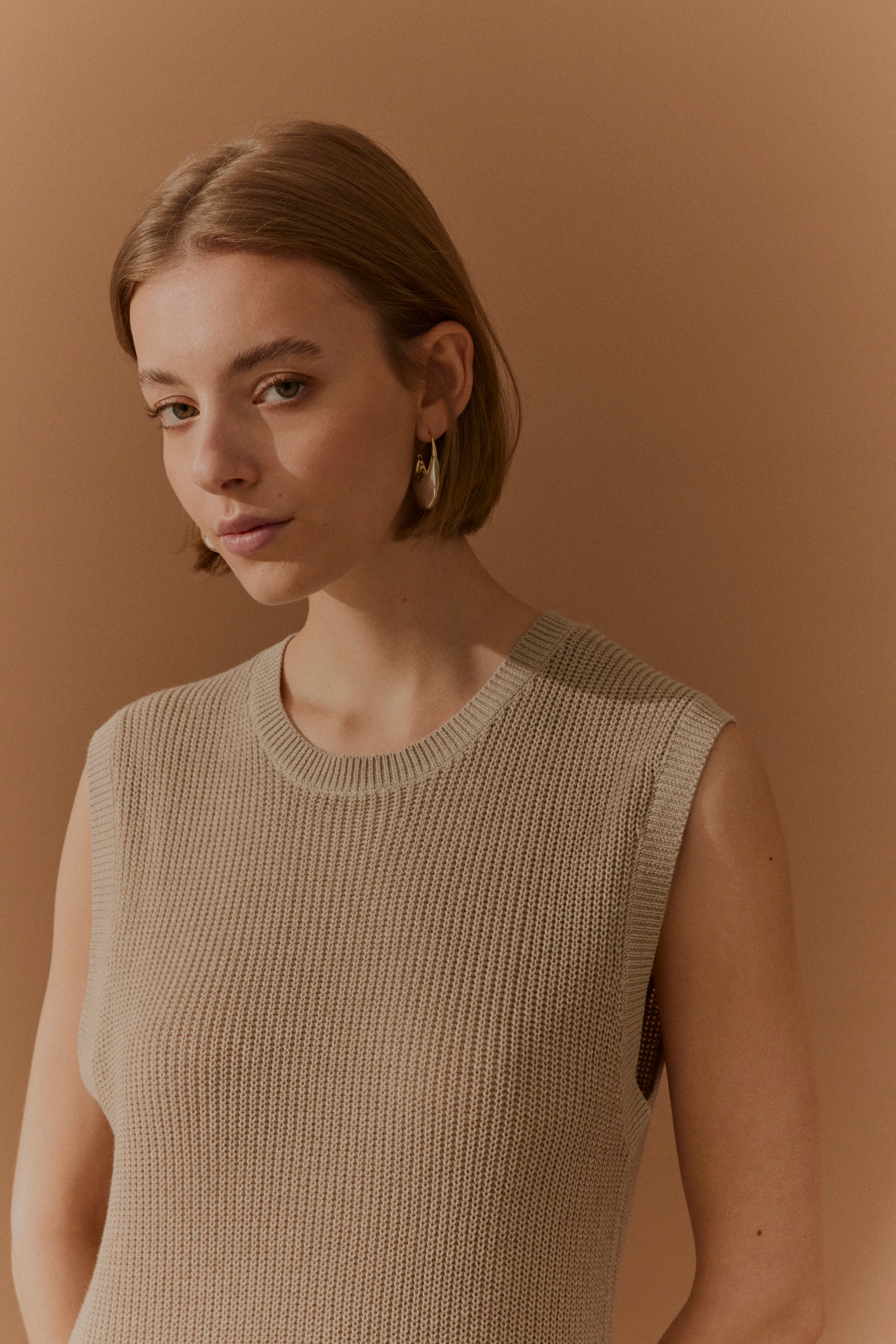 Ärmelloses, beigefarbenes Stricktop von bugatti, Modelbild, lässige Pose.