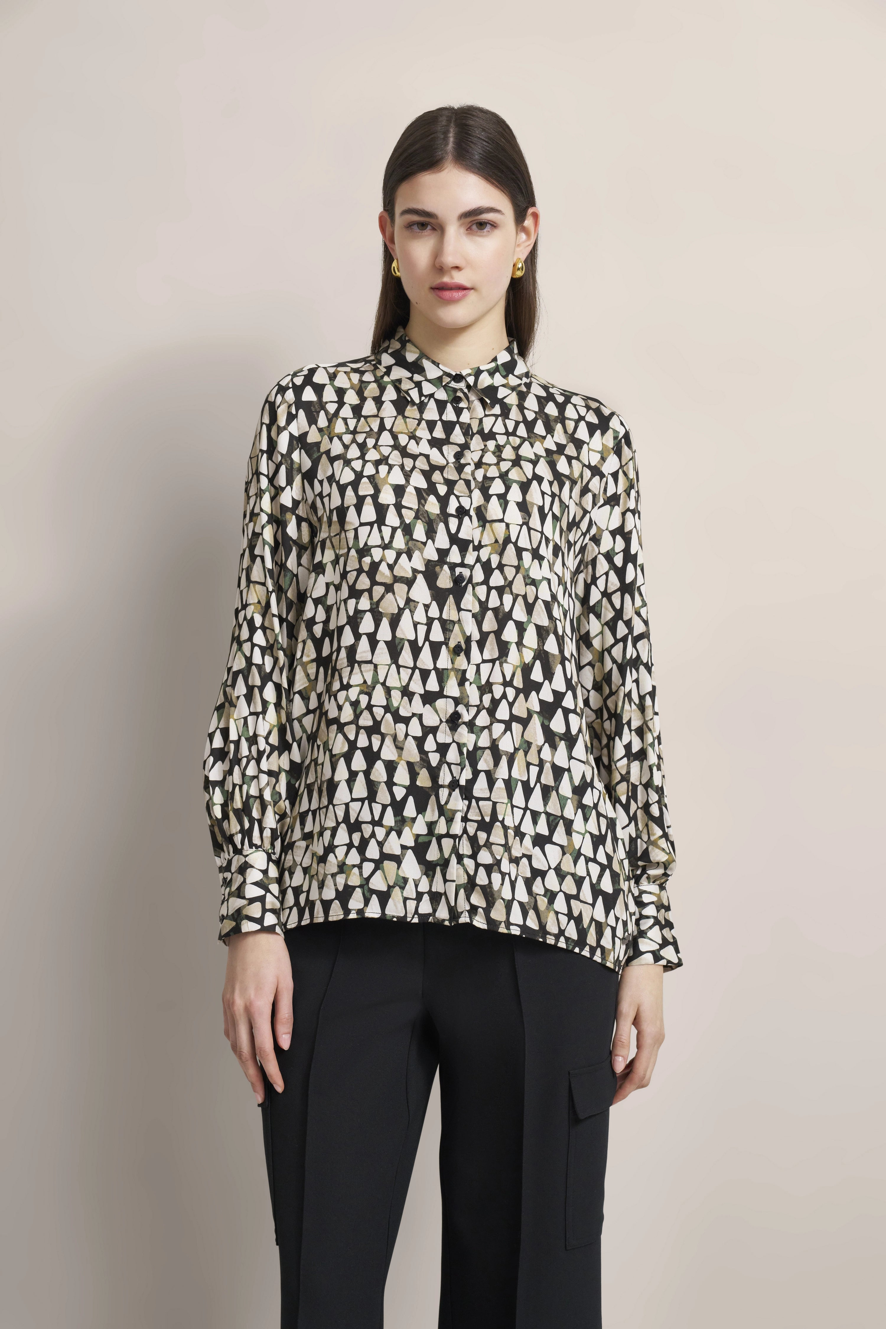 Bluse mit geometrischem Muster in Schwarz-Weiß, Modelbild, entspanntes Posing.