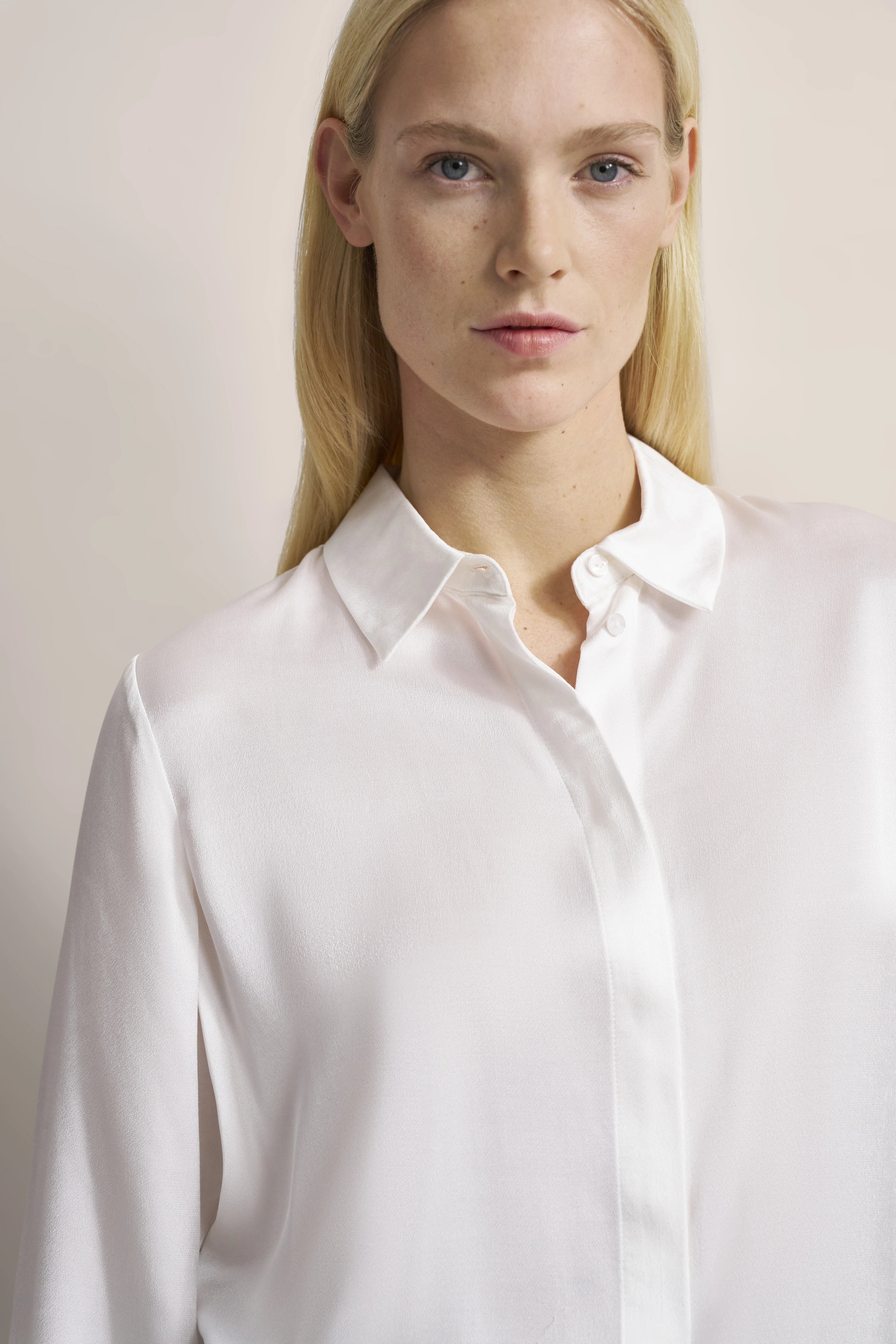 Weiße Bluse von bugatti, Modelbild, schlichtes Design, eleganter Look, Büste frontal.
