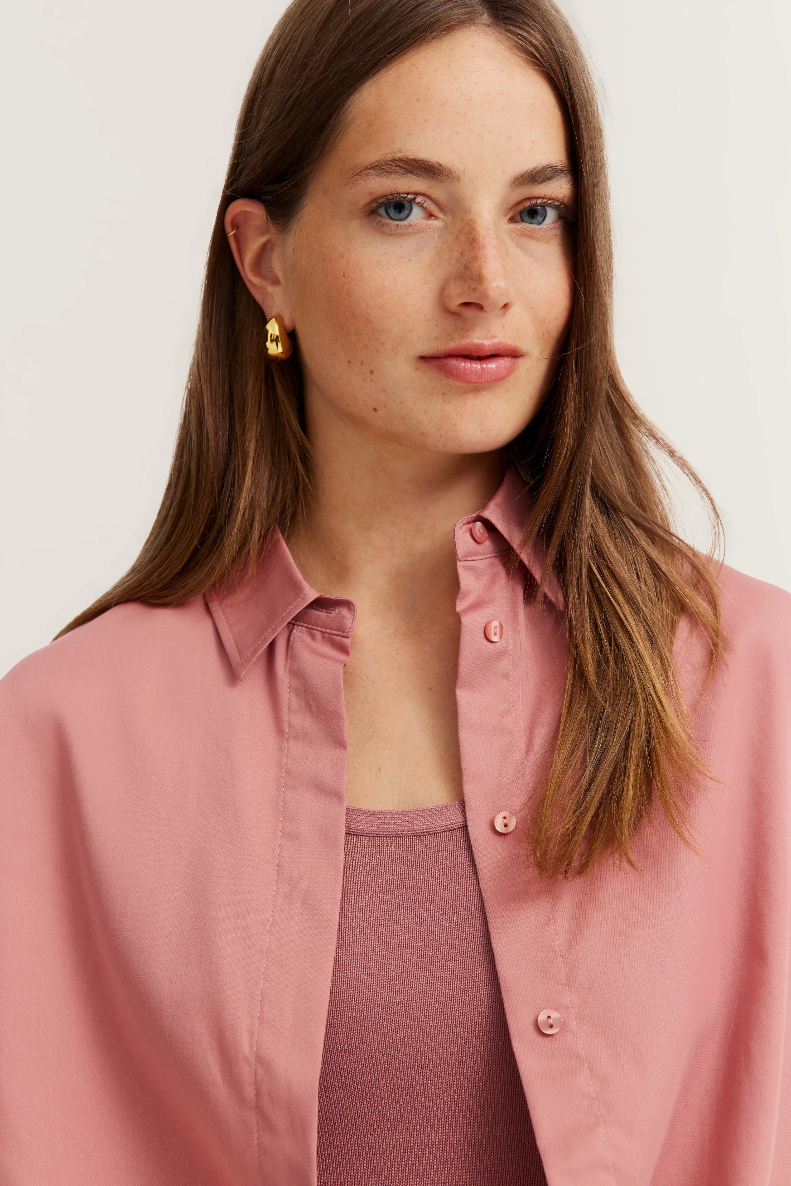 Modelbild, Frau trägt rosa Bluse über passendem Top, entspanntes Posing, bugatti Stil.