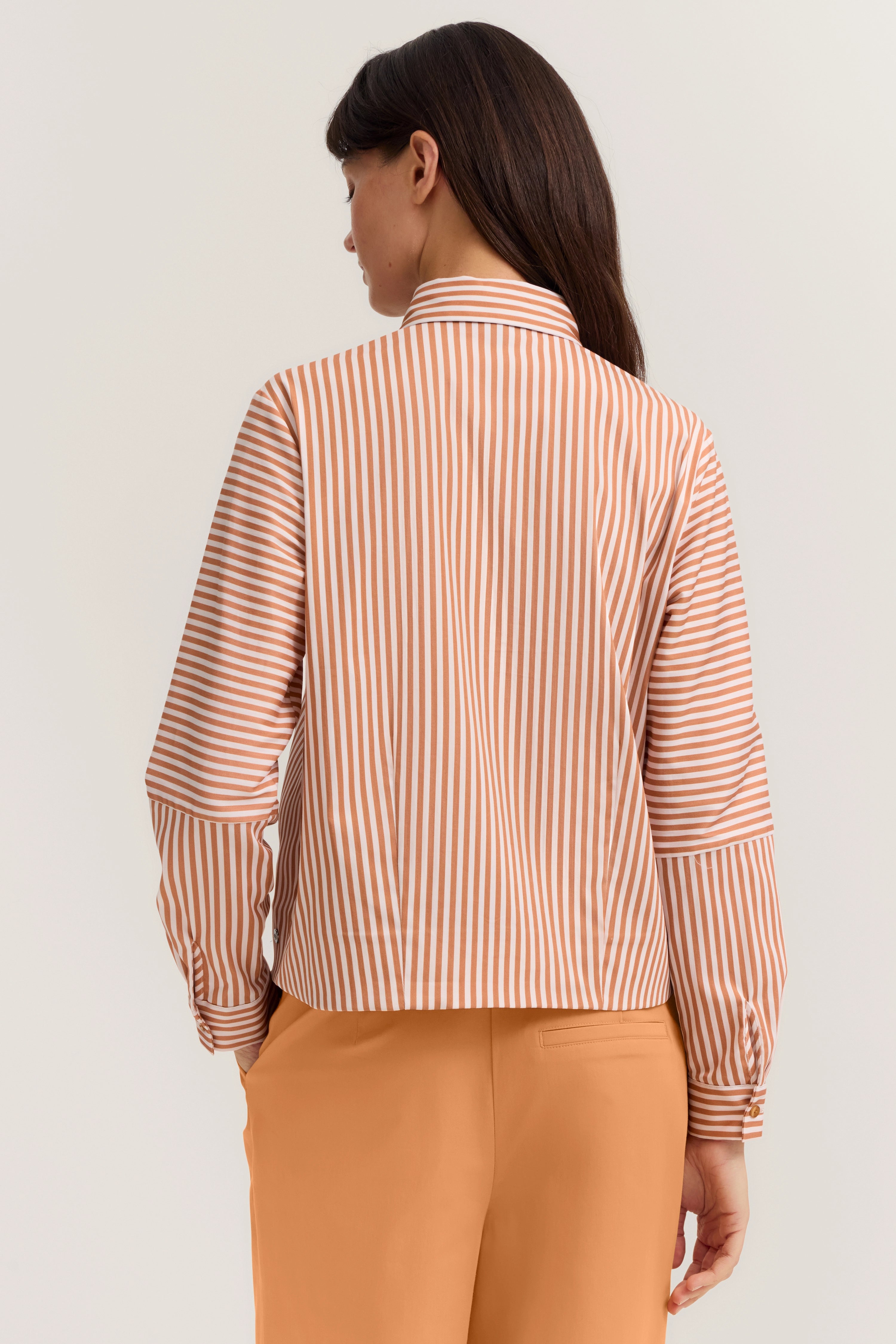 Gestreiftes Hemd in Orange-Weiß mit Büste, kombiniert mit orangefarbener Hose von bugatti.
