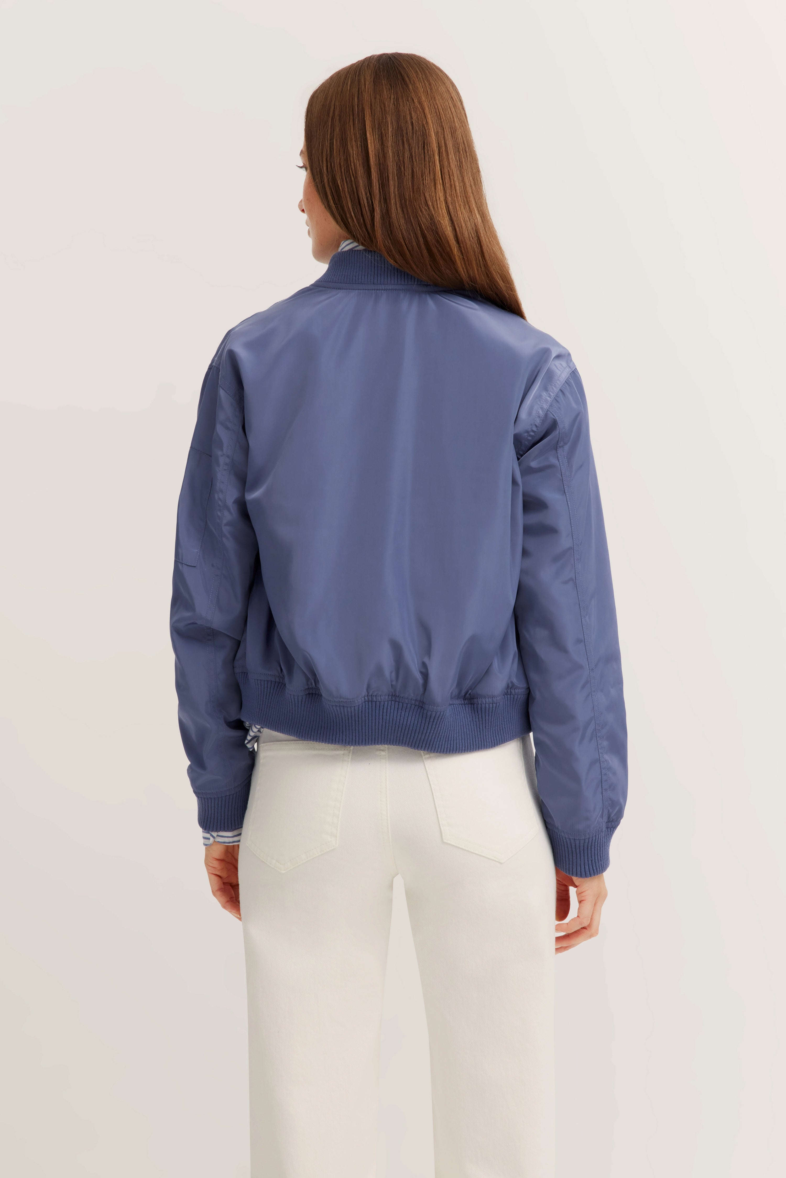 Blaues bugatti Blouson, Rückansicht, casual Look, kombiniert mit weißer Hose.