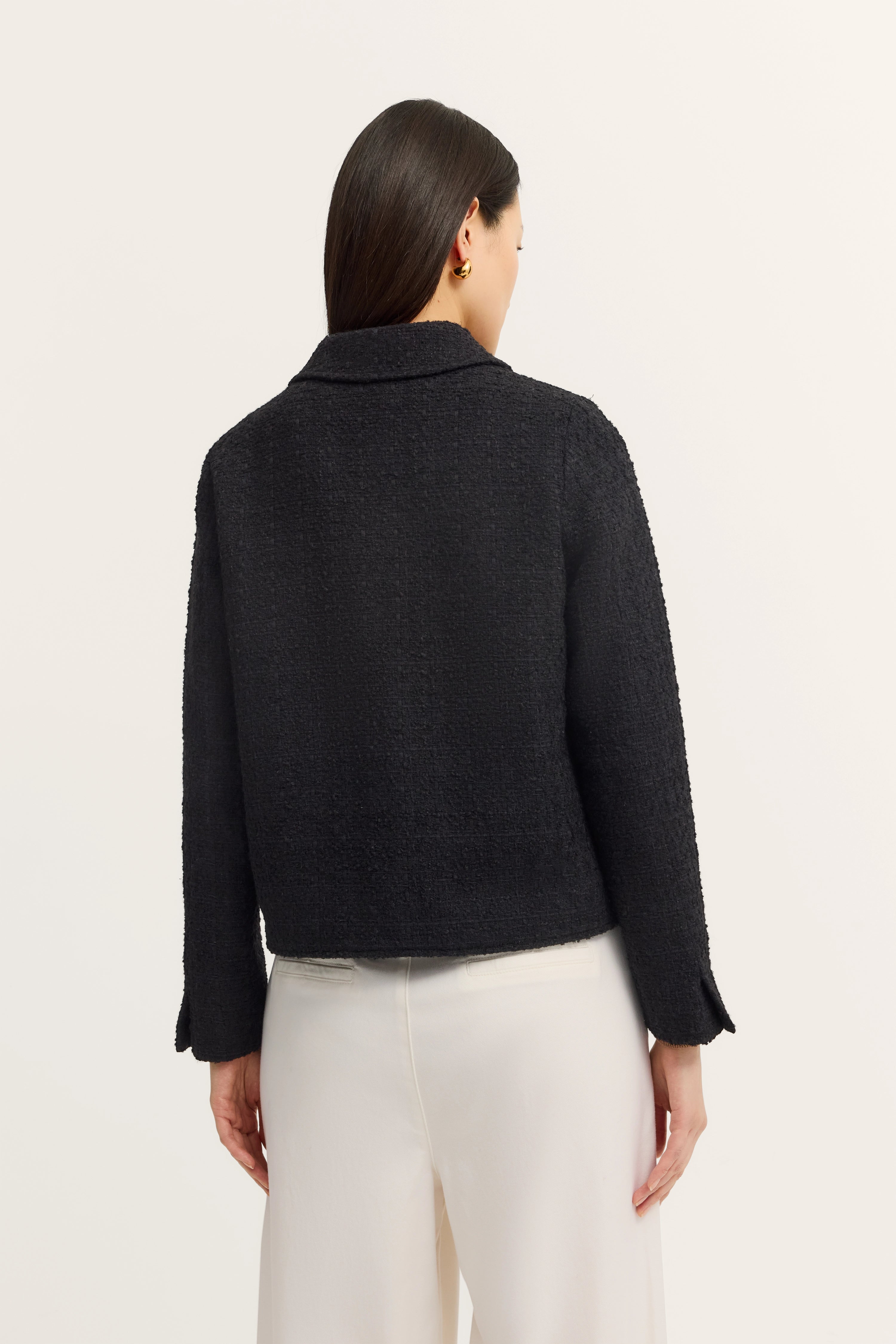 Zwarte bugatti-jas, achterkant op model, gecombineerd met witte broek.