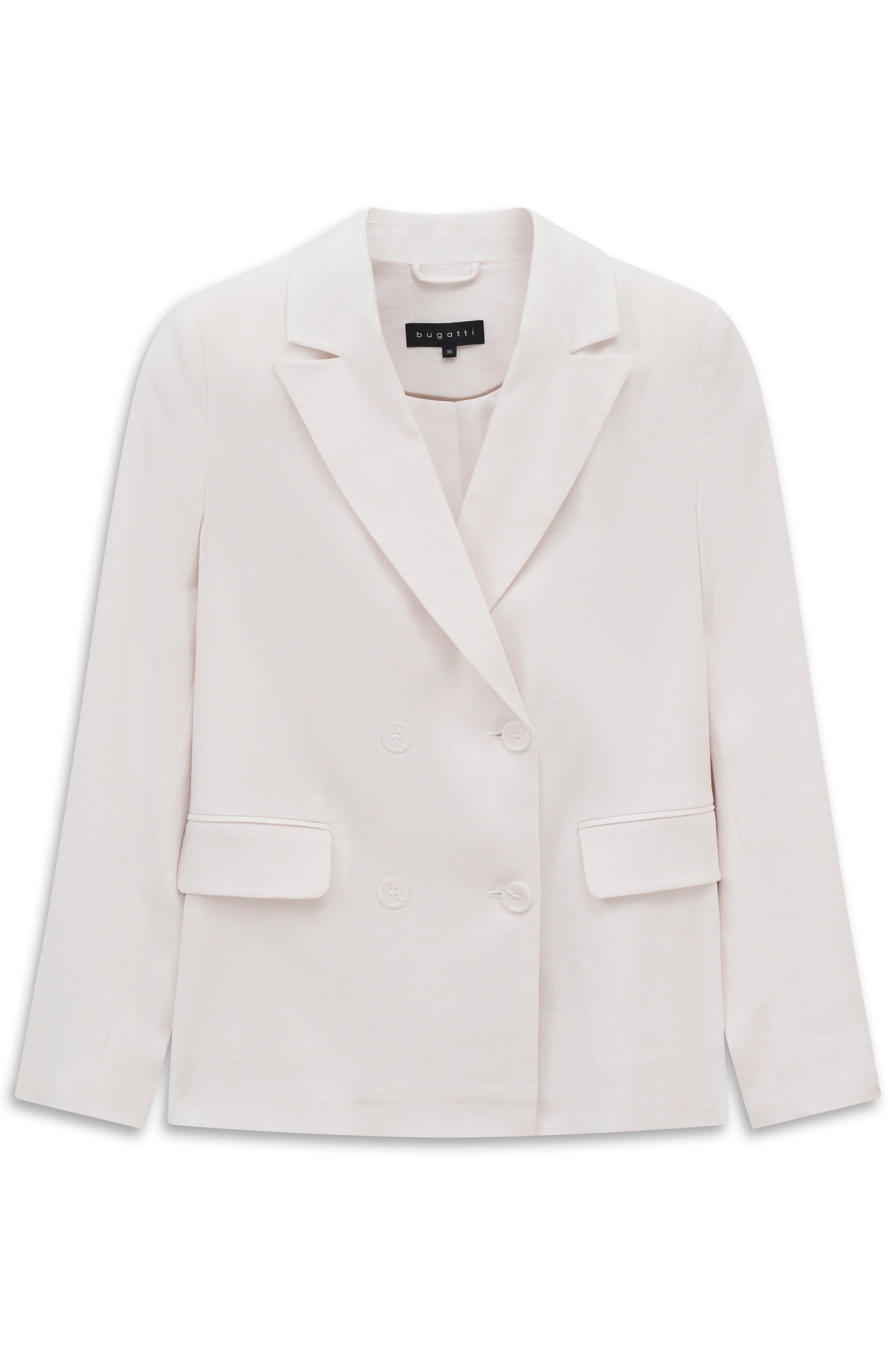 Weißer Blazer, offene Bluse, weite Jeans. Model posiert lässig mit Händen in den Hosentaschen.