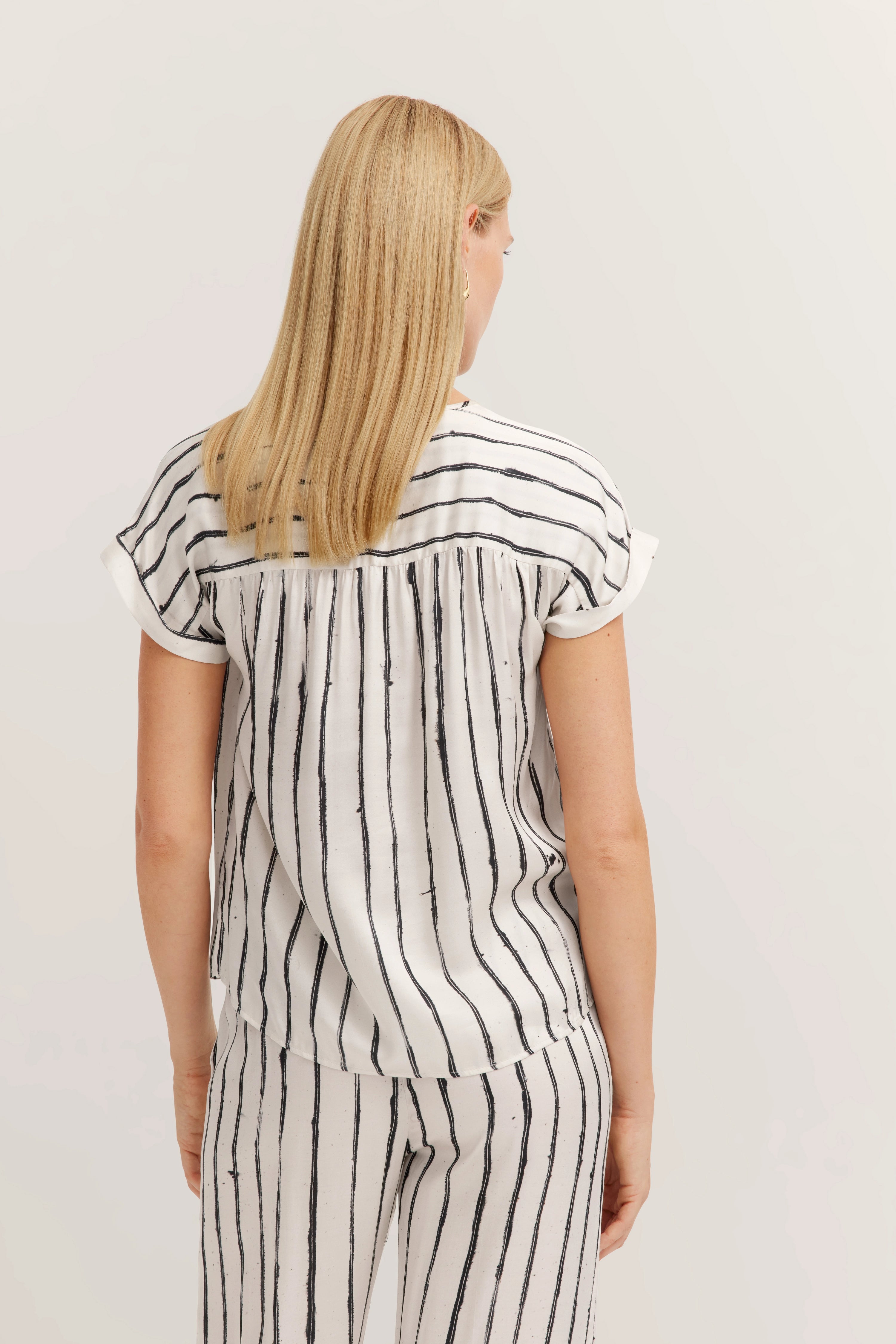 Streifen-Set in Schwarz-Weiß, Modell von hinten, lässige Pose.