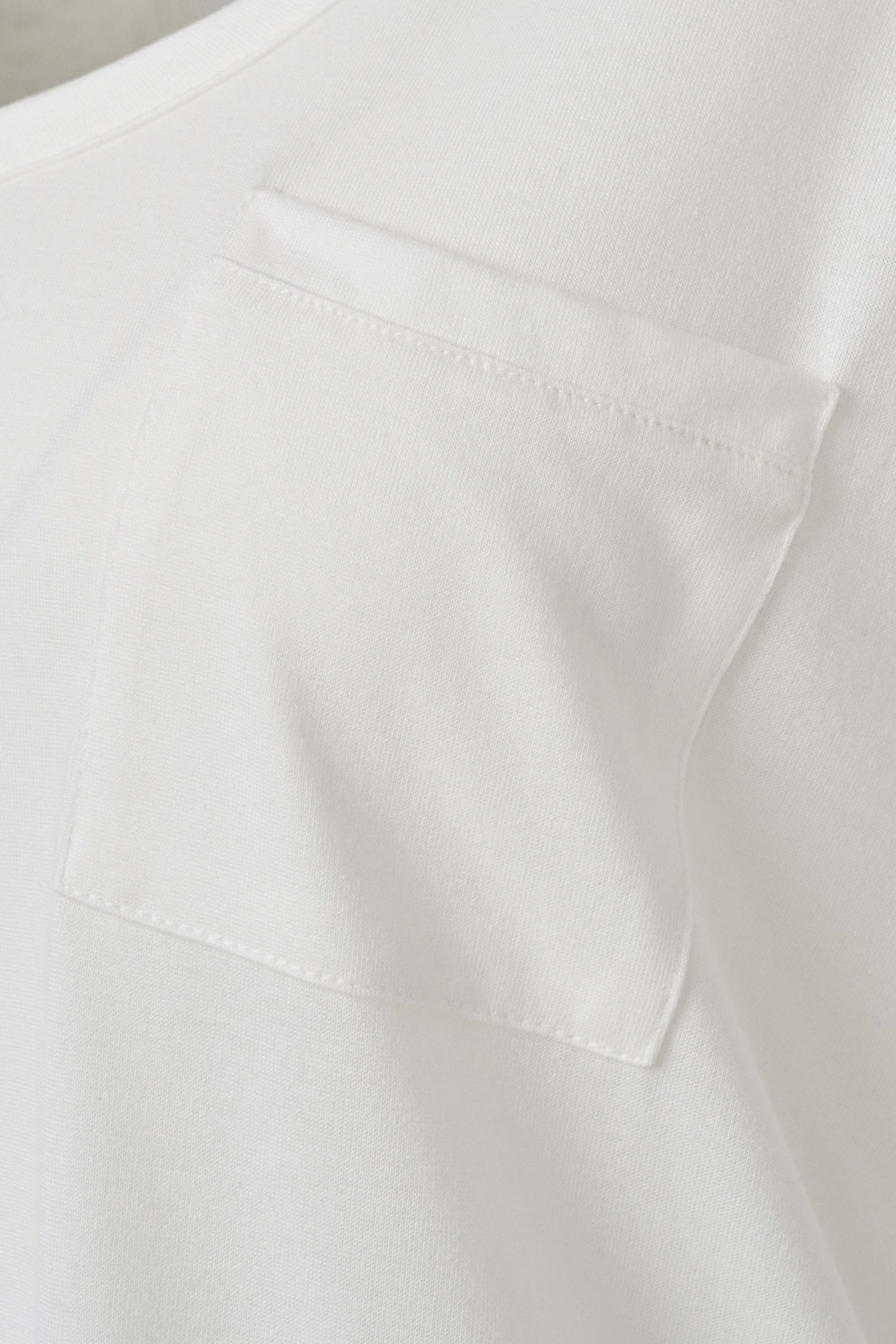 Witte bugatti blouse met borstzak, detail van stofstructuur.