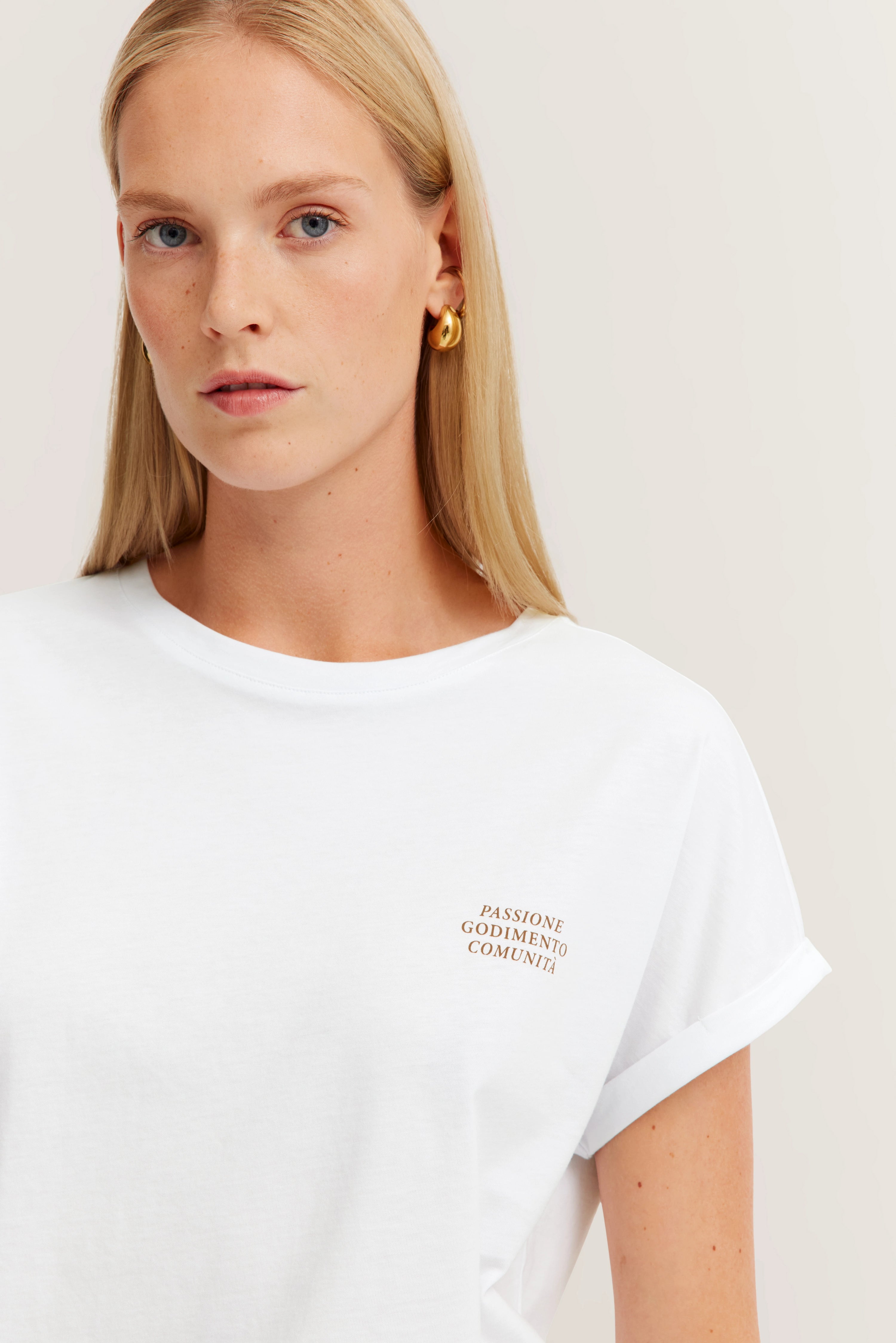 Weißes T-Shirt mit Schriftzug, Modelbild, entspannte Pose.