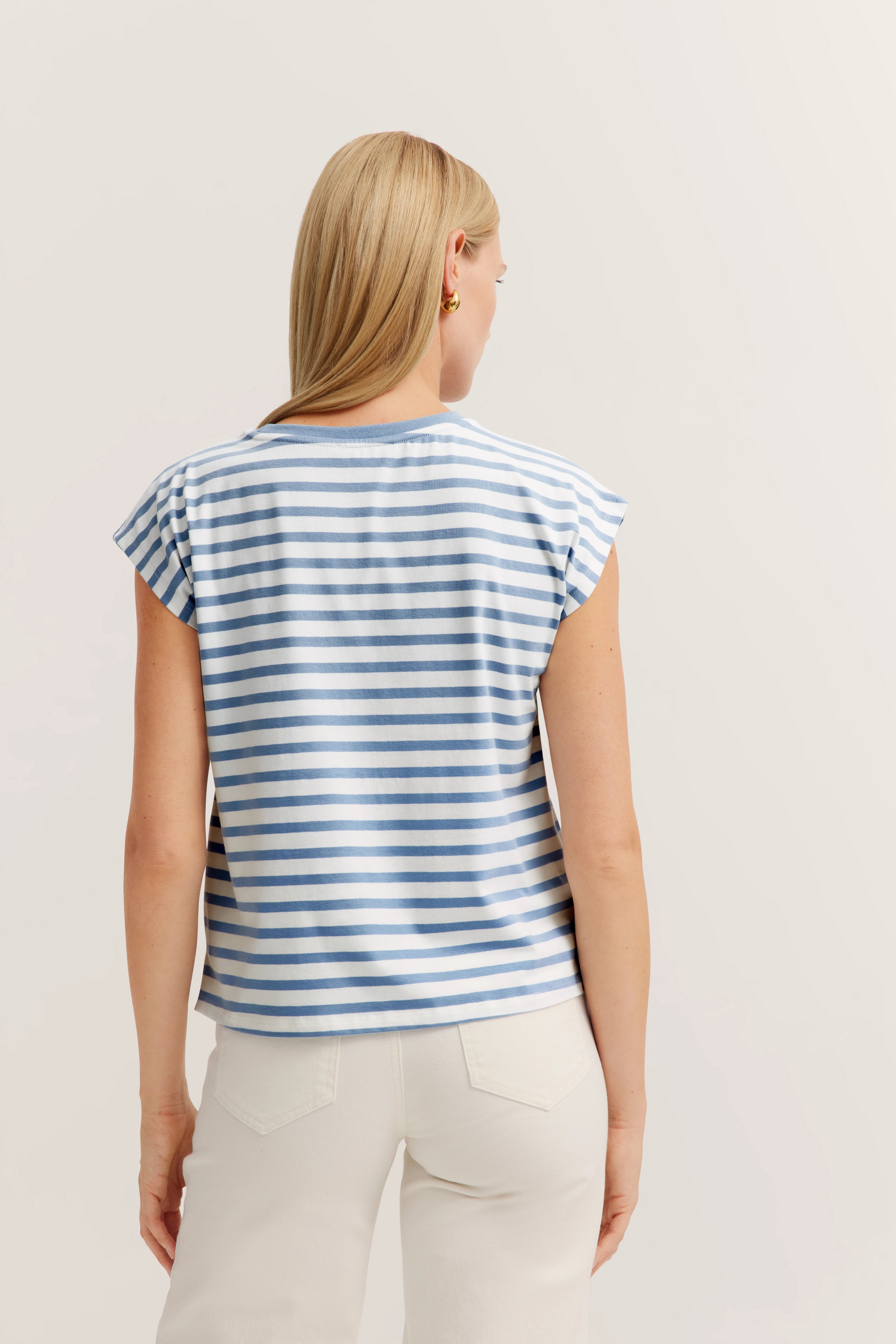 Gestreept blauw-wit shirt, achteraanzicht op model, ontspannen uitstraling.
