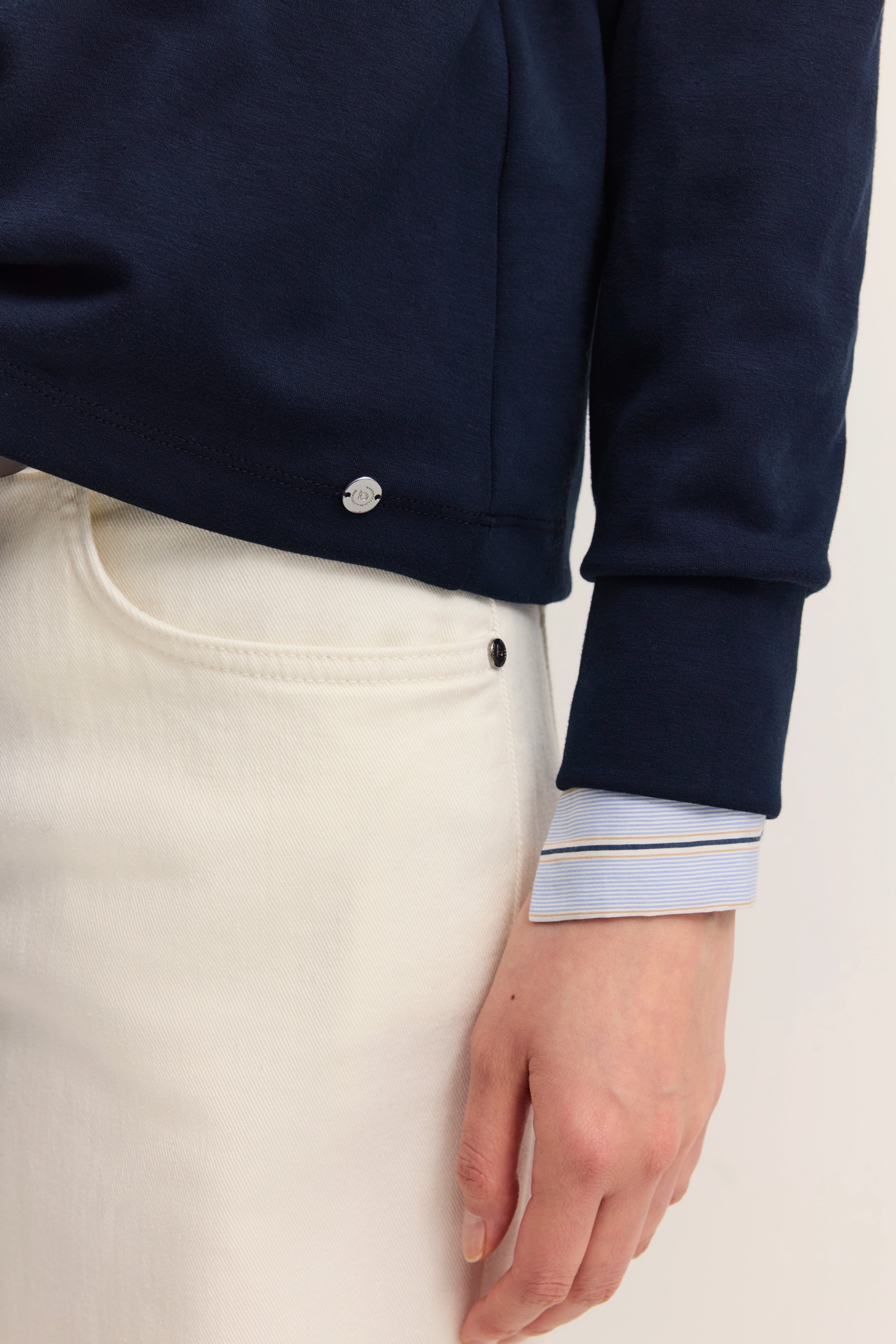 Navy Sweatshirt und weiße Hose Detail, legeres Büstenbild, bugatti Eleganz und Komfort.