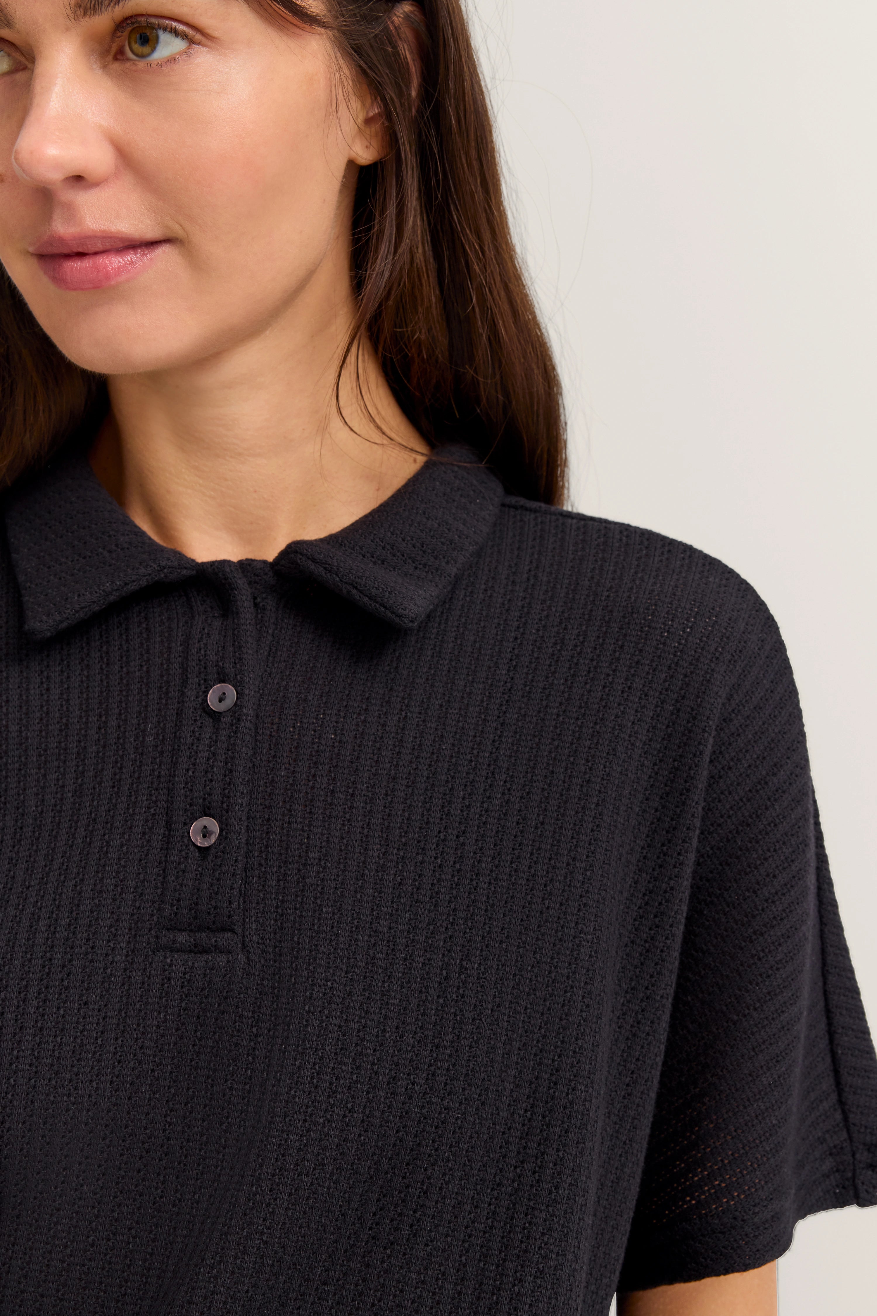 Schwarzes Strick-Poloshirt, Büstenbild mit Knopfleiste, bugatti Stil.