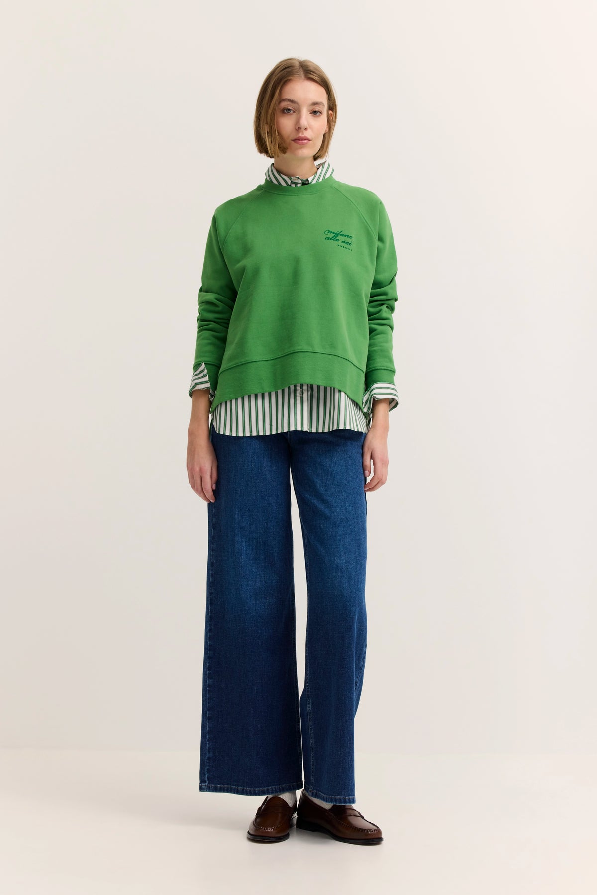 Model mit grünem bugatti Pullover, gestreiftem Hemd, blauer Jeans