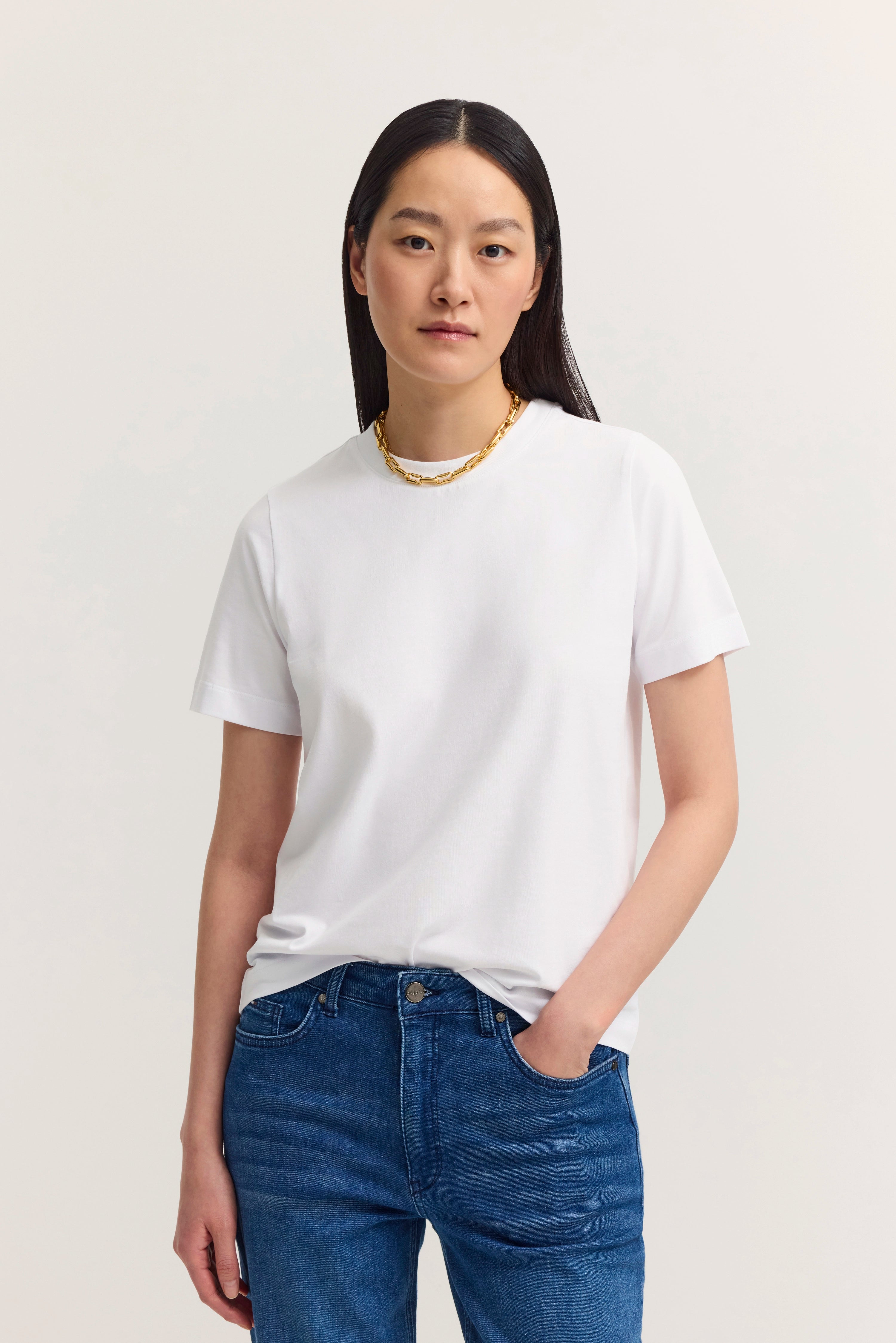 Weißes T-Shirt und blaue Jeans, Modelbild mit entspanntem Posing, bugatti Stil.