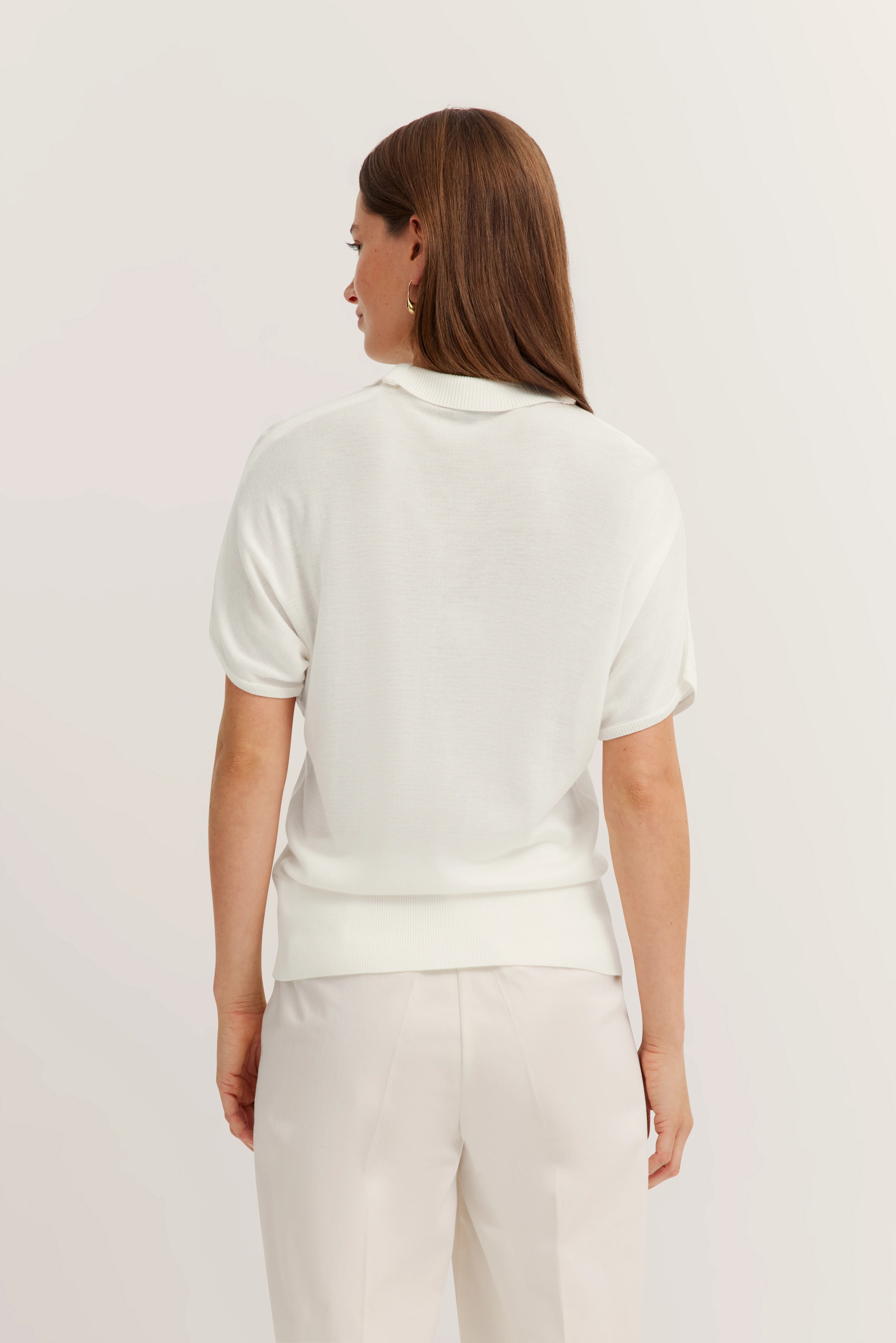 Weiße bugatti Bluse und Hose, Model von hinten, legerer Look.