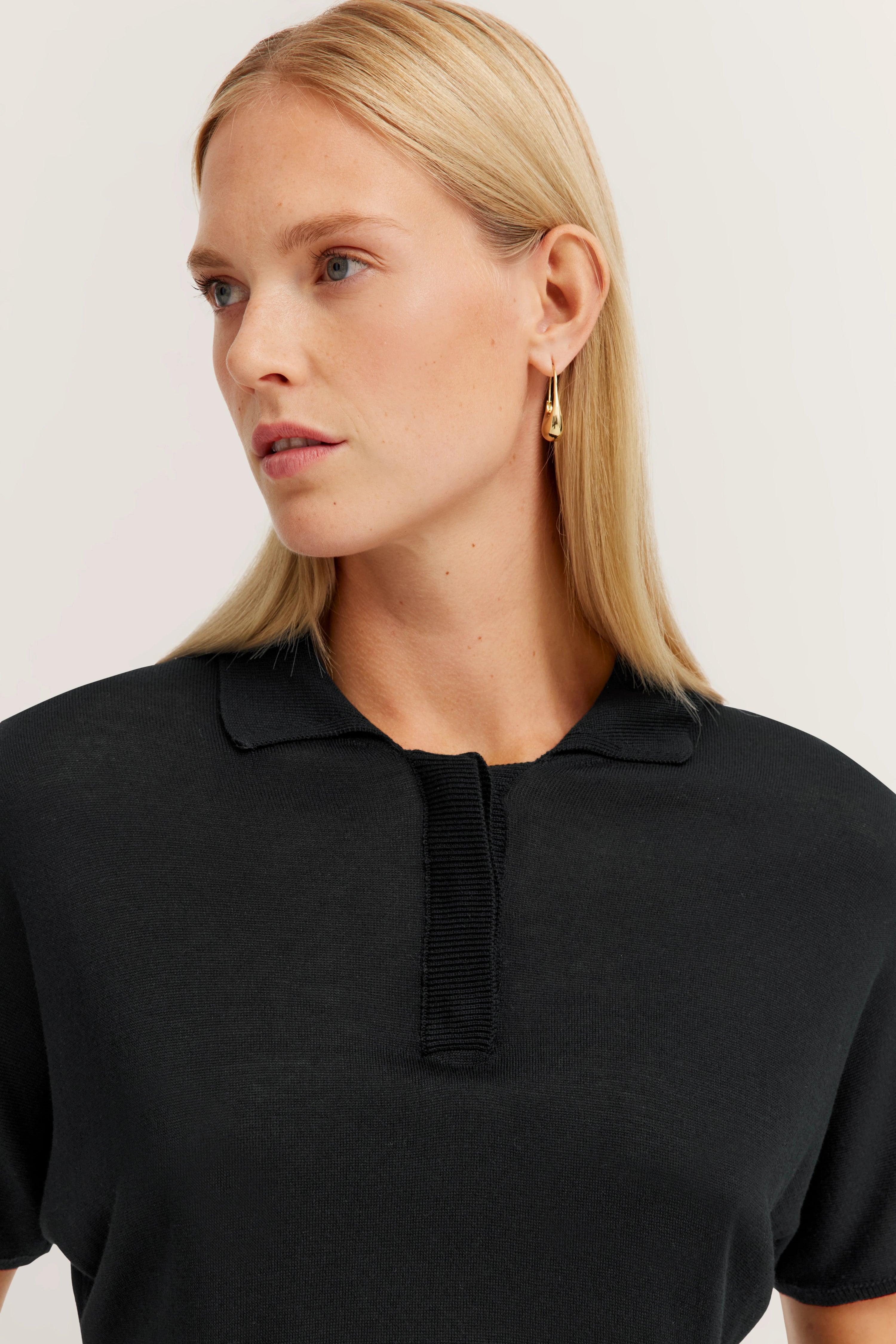 Schwarzes bugatti Poloshirt in Büstenansicht, Model schaut nach links.