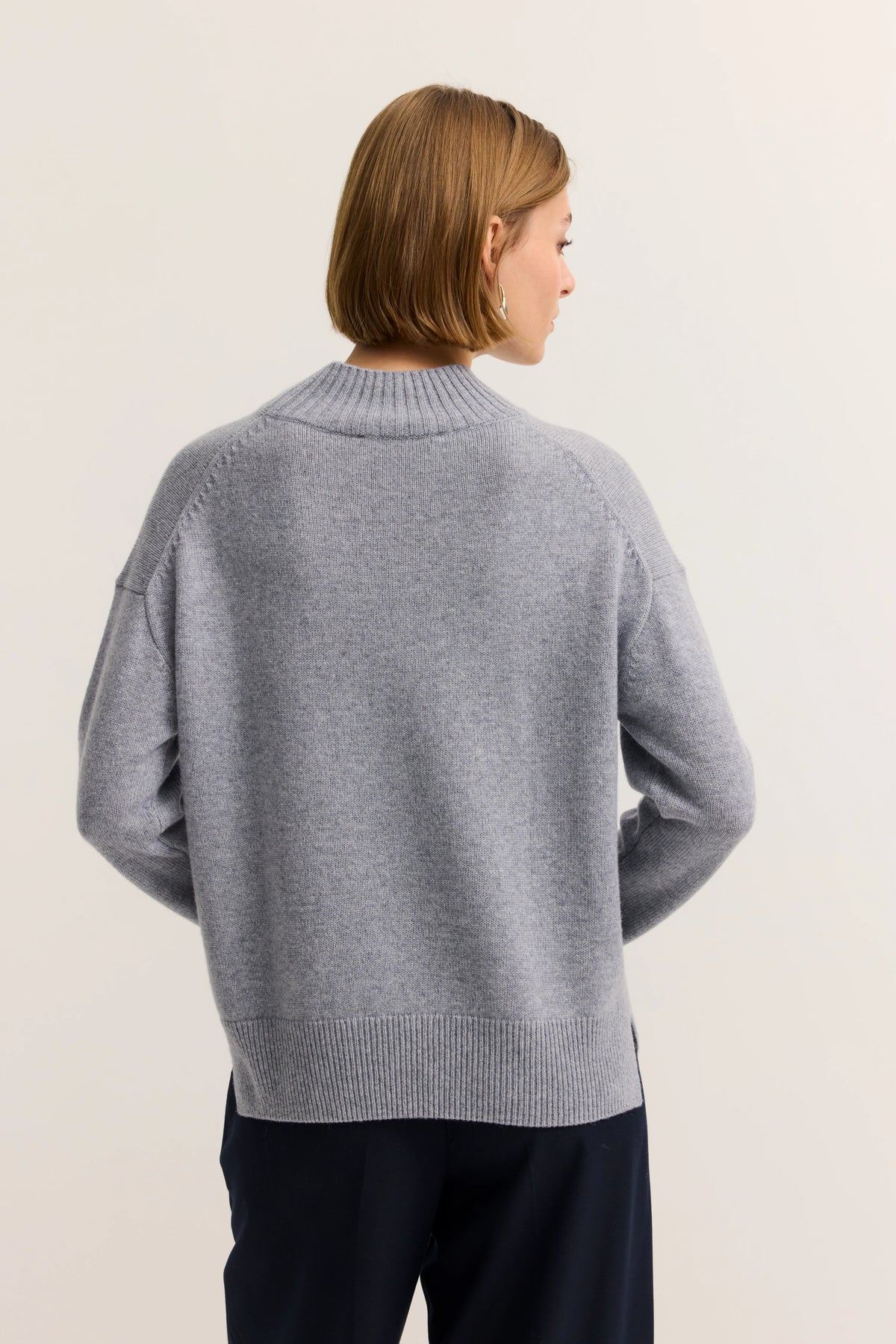 Grauer Pullover von bugatti, leger getragen, Seitenansicht, mit dunkler Hose kombiniert.