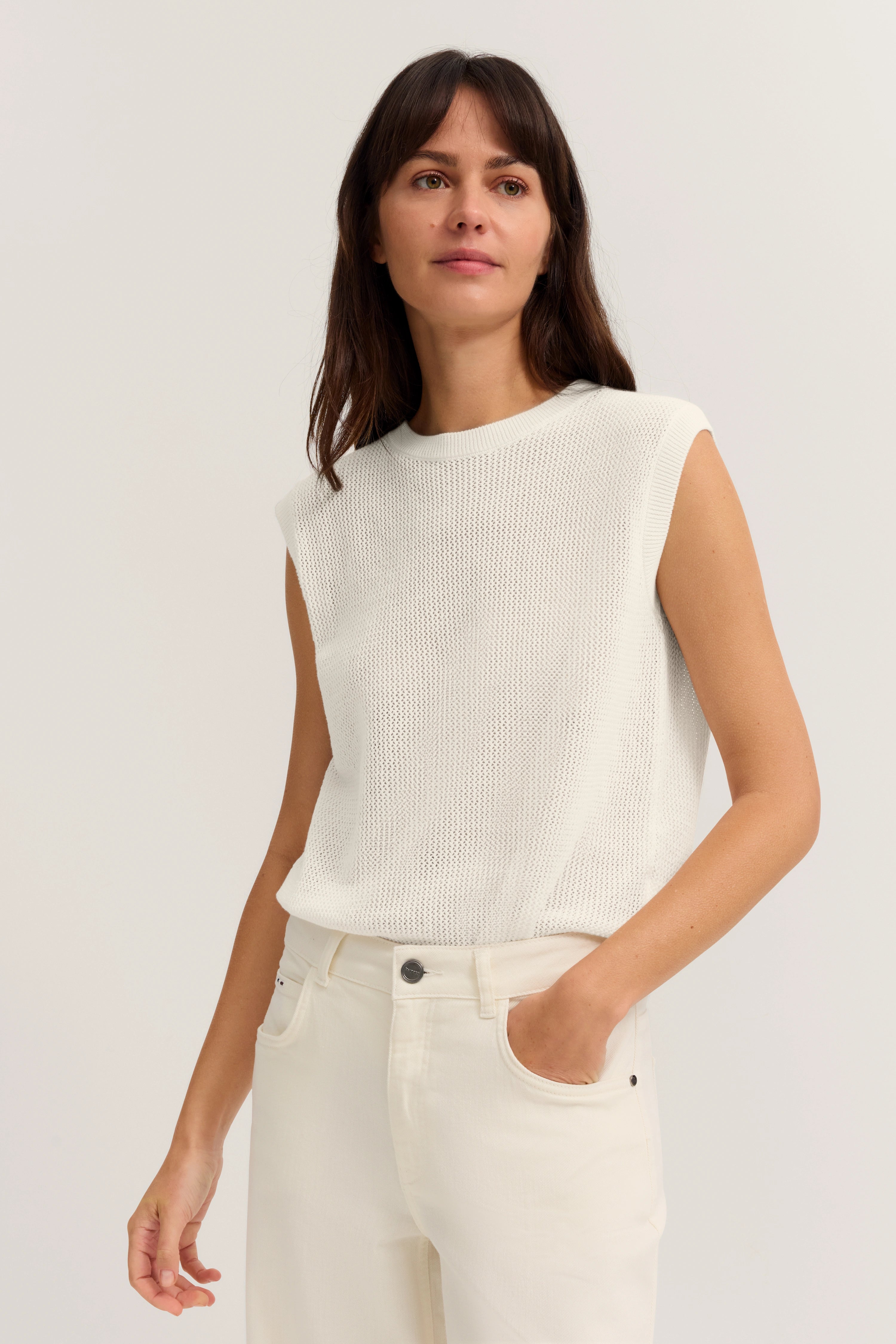 Weißes ärmelloses Top und Jeans, Modelpose, Hand in Tasche, bugatti Stil.