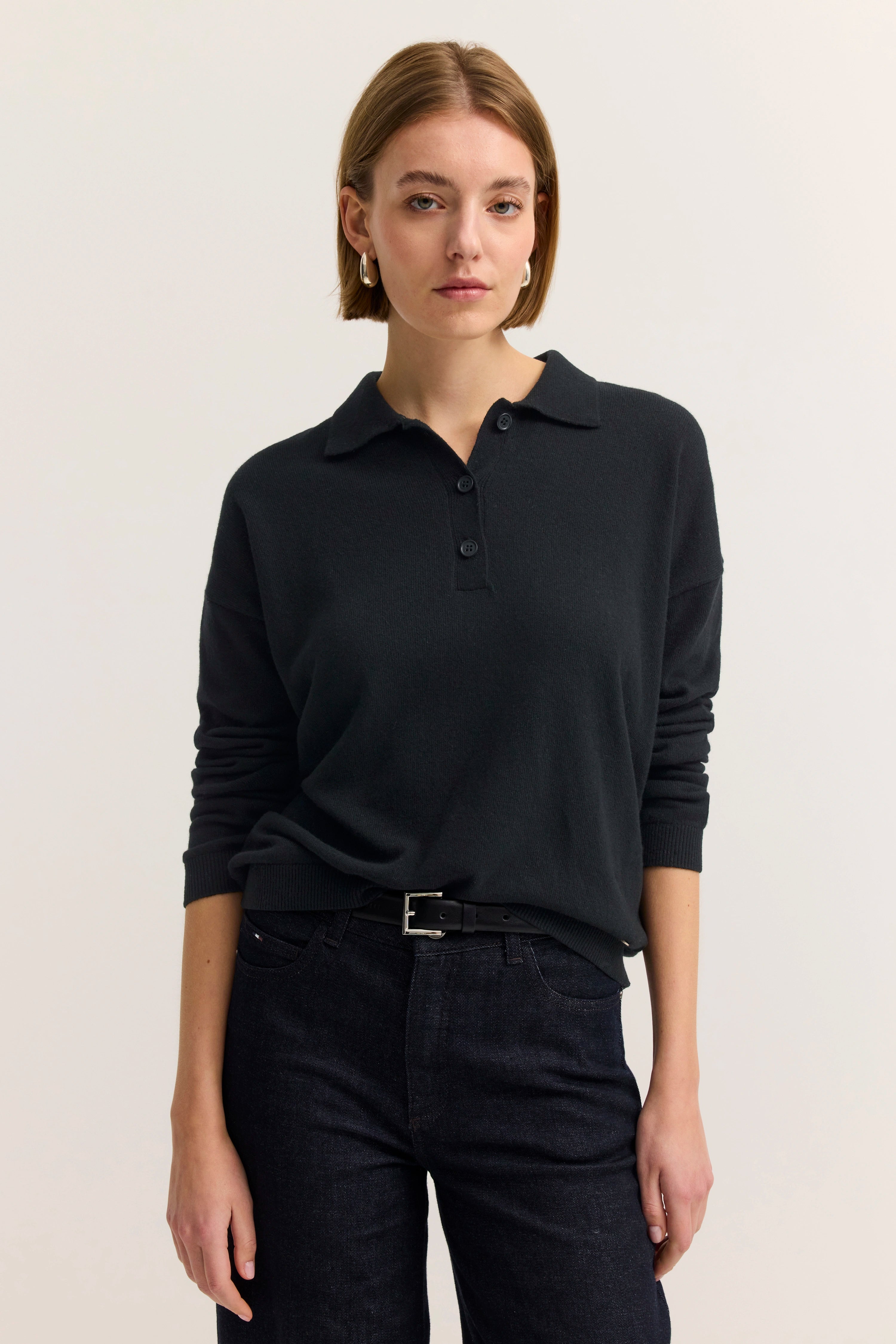 Schwarzer bugatti Pullover und Jeans, legeres Modelbild mit entspannter Pose.
