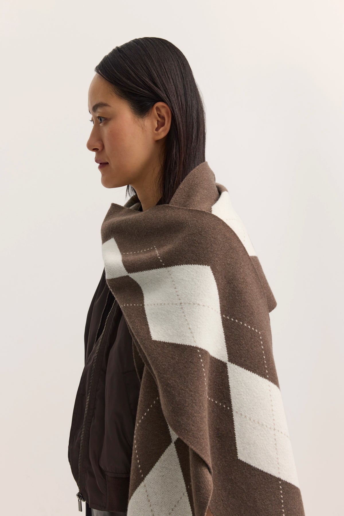 Braune Jacke mit braun-weißem Karoschal, Seitenansicht, Model trägt lockeres Haar.