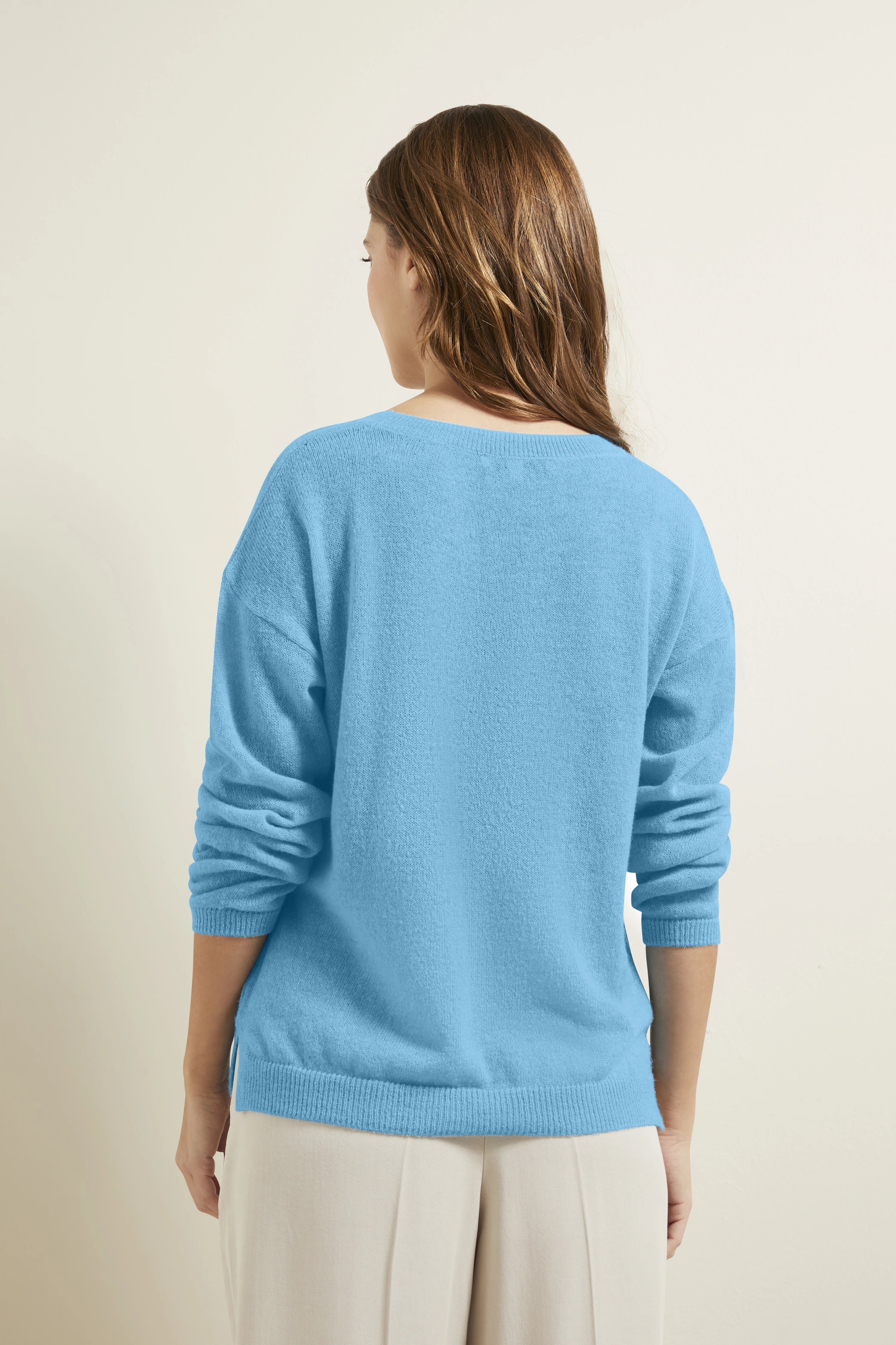 Blauer Pullover von bugatti, Rückenansicht, lässig getragen mit beigen Hosen, Modelbild von hinten.