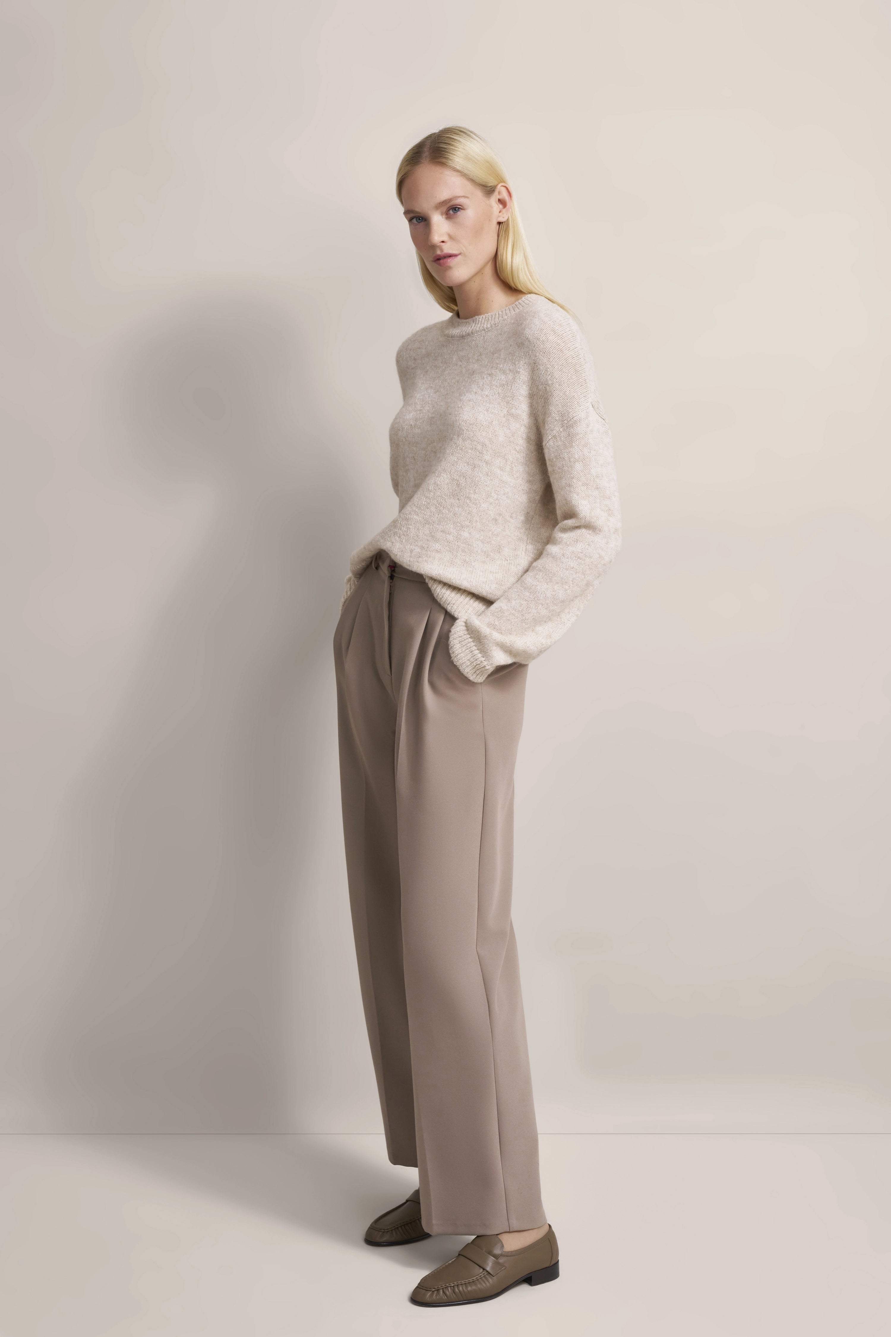 Model in beige Pullover, taupe Hose