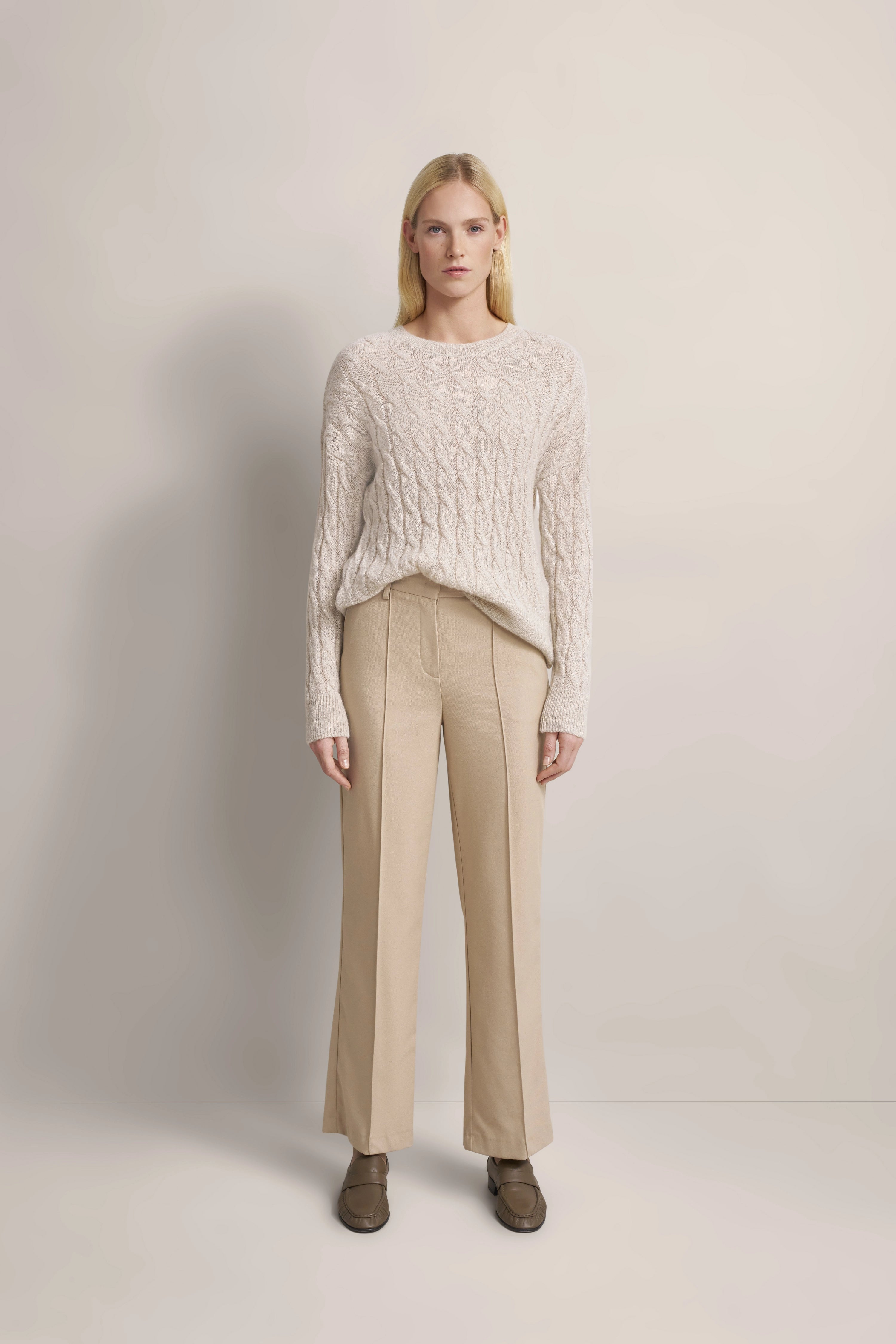 Beige Strickpullover und Hose, Modelbild, entspannte Pose, bugatti Stil.